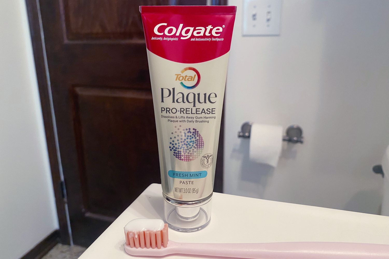 The Colgate Total Plaque Pro-Release Fresh Mint Toothpaste tube in a bathroom