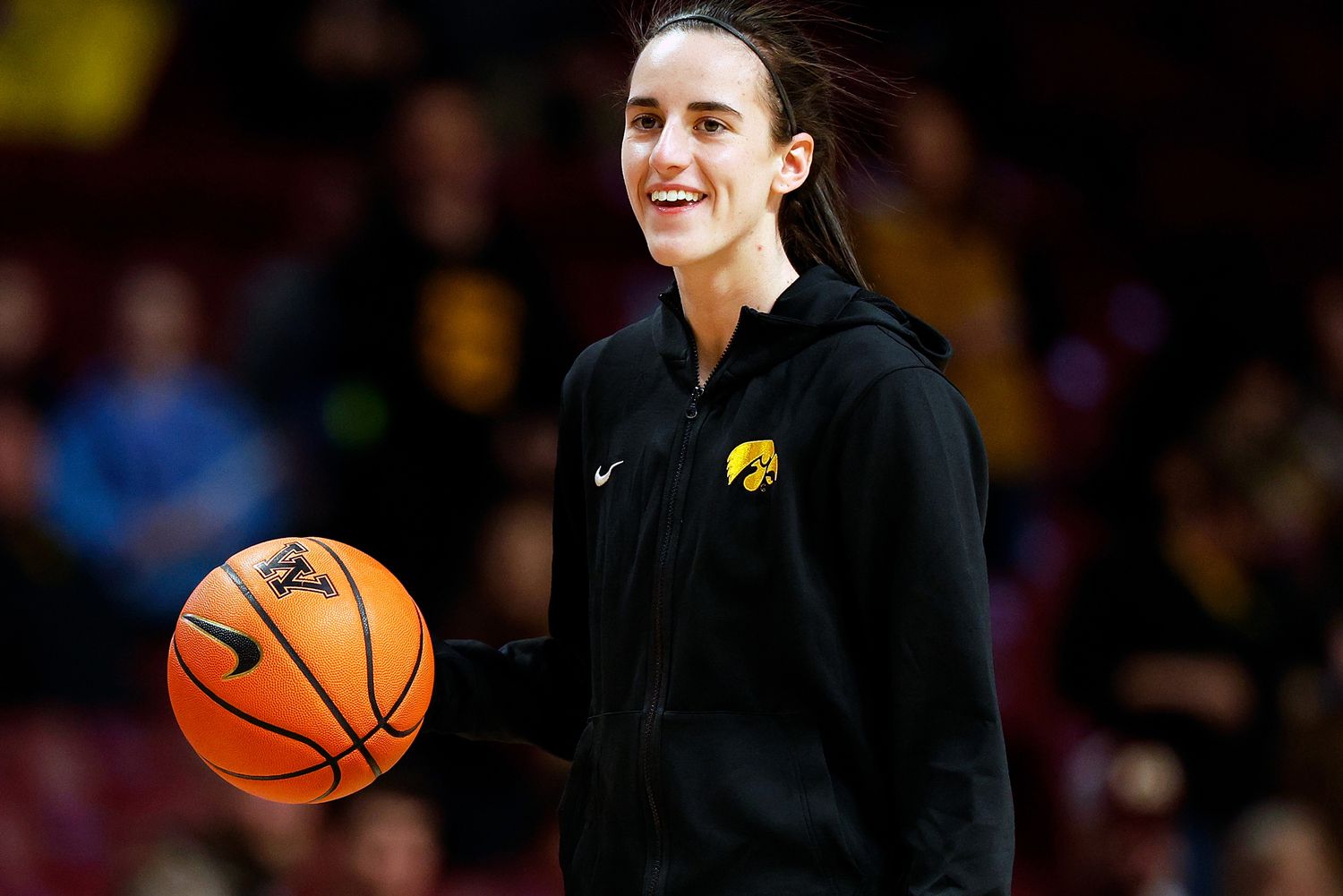 Caitlin Clark of the Iowa Hawkeyes smiles as she warms up prior to the start of the game against the Minnesota Golden Gophers at Williams Arena on February 28, 2024