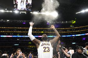Los Angeles Lakers forward LeBron James tosses powder in the air prior to an NBA basketball game against the Denver Nuggets 