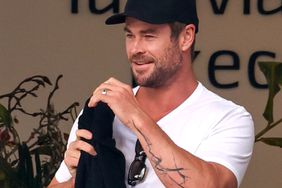 Chris Hemsworth shows off his new abstract arm tattoo when making his way through the airport with his wife Elsa Pataky.