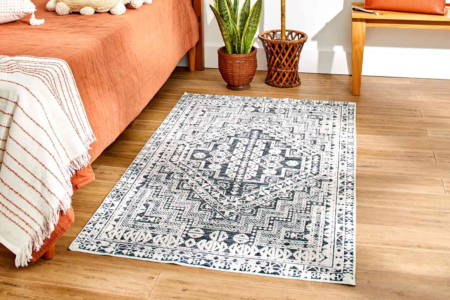 The World Market Iman Black And Ivory Persian Style Washable Area Rug in a bedroom setting