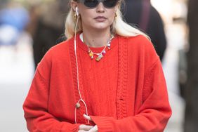 Gigi Hadid heads home in one of her own red knitted cardigans after lunch in New York City.