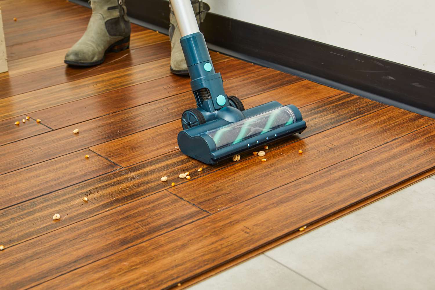 The Belife V12 Cordless Vacuum Cleaner being used to vacuum cereal off a wood floor.
