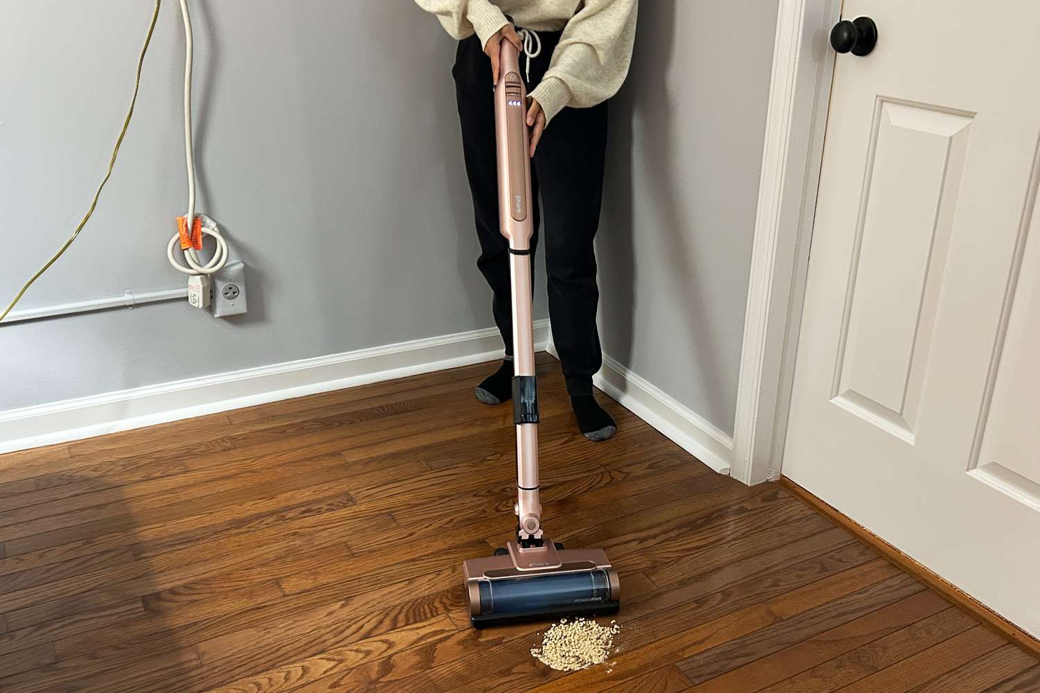 A person uses the Shark Wandvac (without self-empty feature) on a wooden floor 