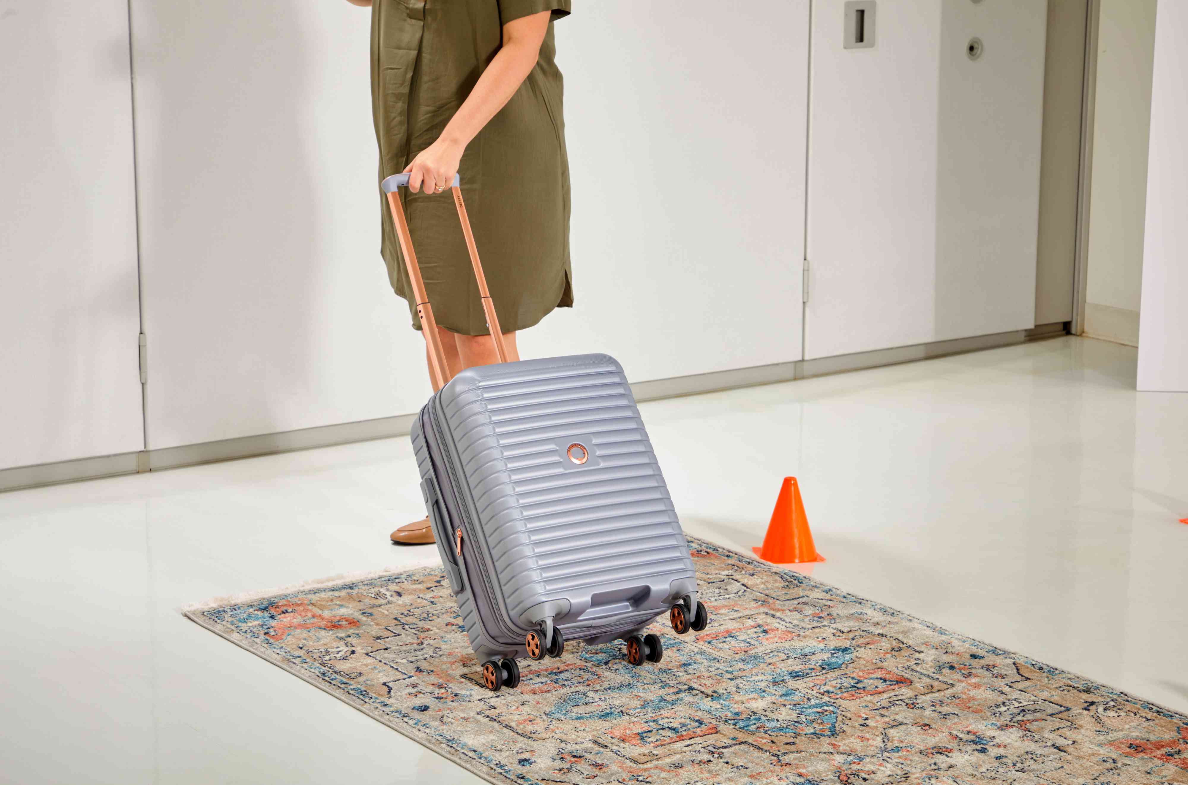 Delsey Cruise 3.0 Carry-on - 21" being rolled on a rug by a person