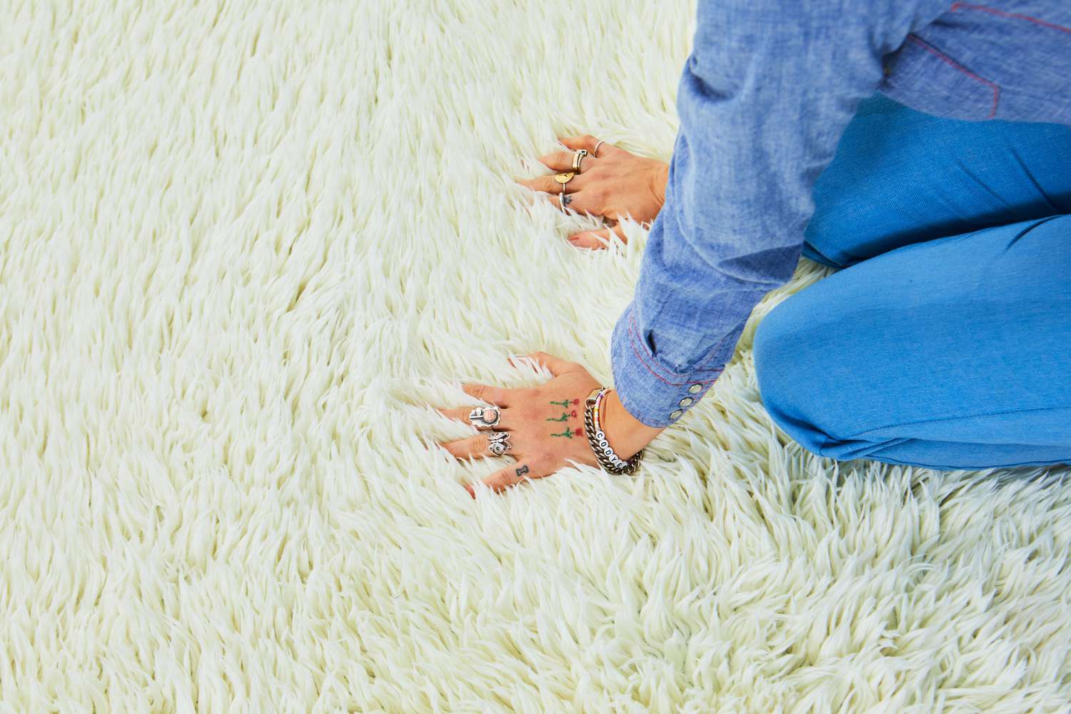 A person kneeling down and touching the Ruggable Shag Rug