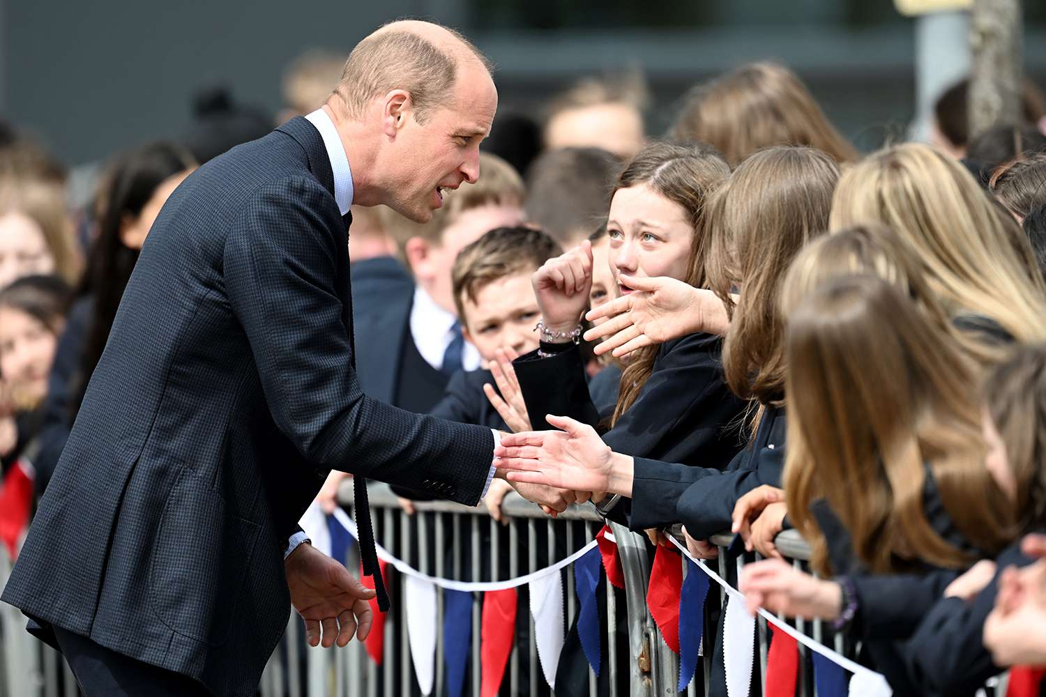 Prince William, Prince of Wales is greeted by school children upon his visit to St. Michael's Church of England School on April 25, 2024 in Birmingham, England.