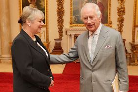 King Charles III (R) greets Dame Martina Milburn (R) prior to an audience with community faith leaders from across the UK who have taken part in a Windsor Leadership Trust programme, encouraging and supporting dialogue, harmony and understanding at a time of heightened international tension, at Buckingham Palace on March 26, 2024 in London,