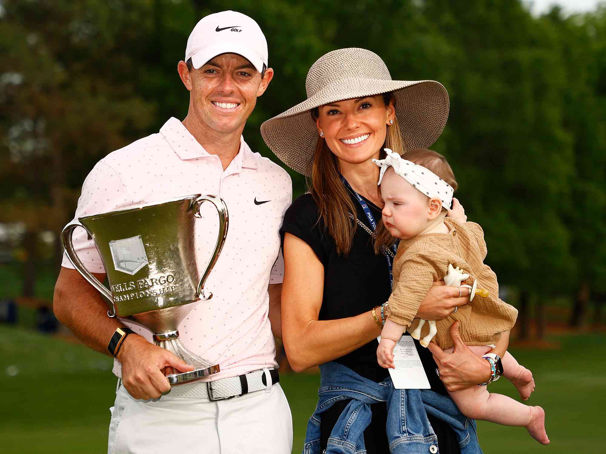 Rory McIlroy of Northern Ireland celebrates with the trophy alongside his wife Erica and daughter Poppy after winning during the final round of the 2021 Wells Fargo Championship