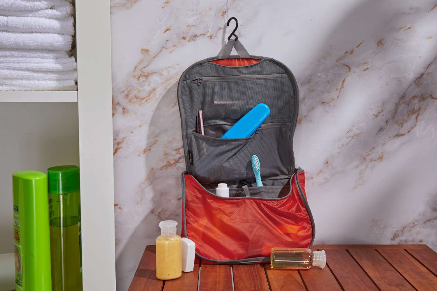 Sea to Summit Travelling Light Hanging Toiletry Bag on top of a wooden table 