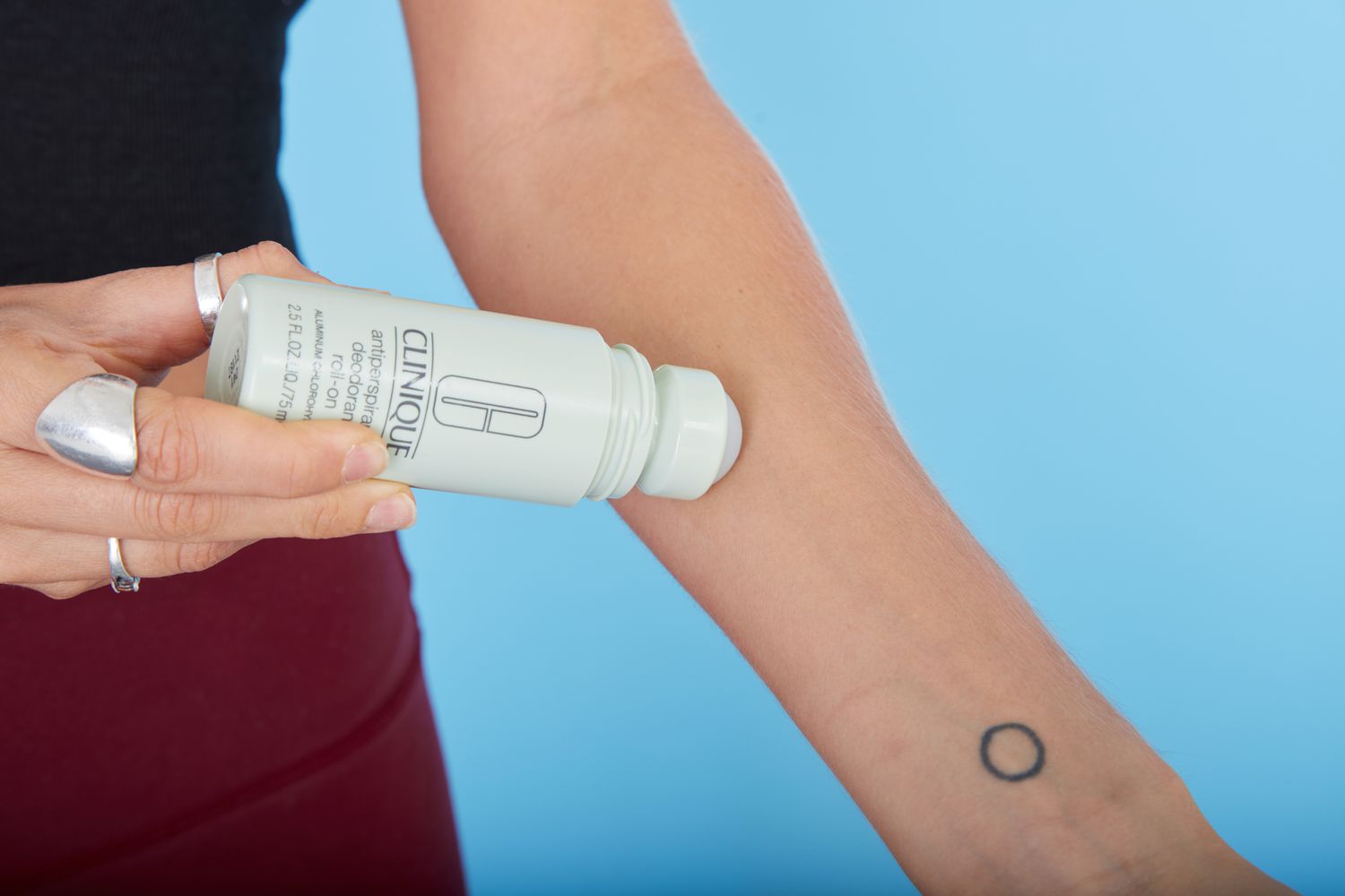 Person applying Clinique Antiperspirant Deodorant Roll-On to their forearm