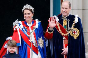 Prince Louis of Wales, Catherine, Princess of Wales (wearing the Mantle of the Royal Victorian Order) and Prince William, Prince of Wales (wearing the Mantle of the Order of the Garter) watch an RAF flypast from the balcony of Buckingham Palace following the Coronation of King Charles III & Queen Camilla at Westminster Abbey on May 6, 2023