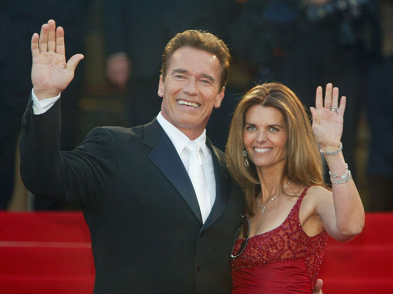Arnold Schwarzenegger with his wife Maria Shriver wave to fans as the couple arrives for the screening of the film "Les Egares" at the Palais des Festivals during the 56th International Cannes Film Festival on May 16, 2003 in Cannes, France