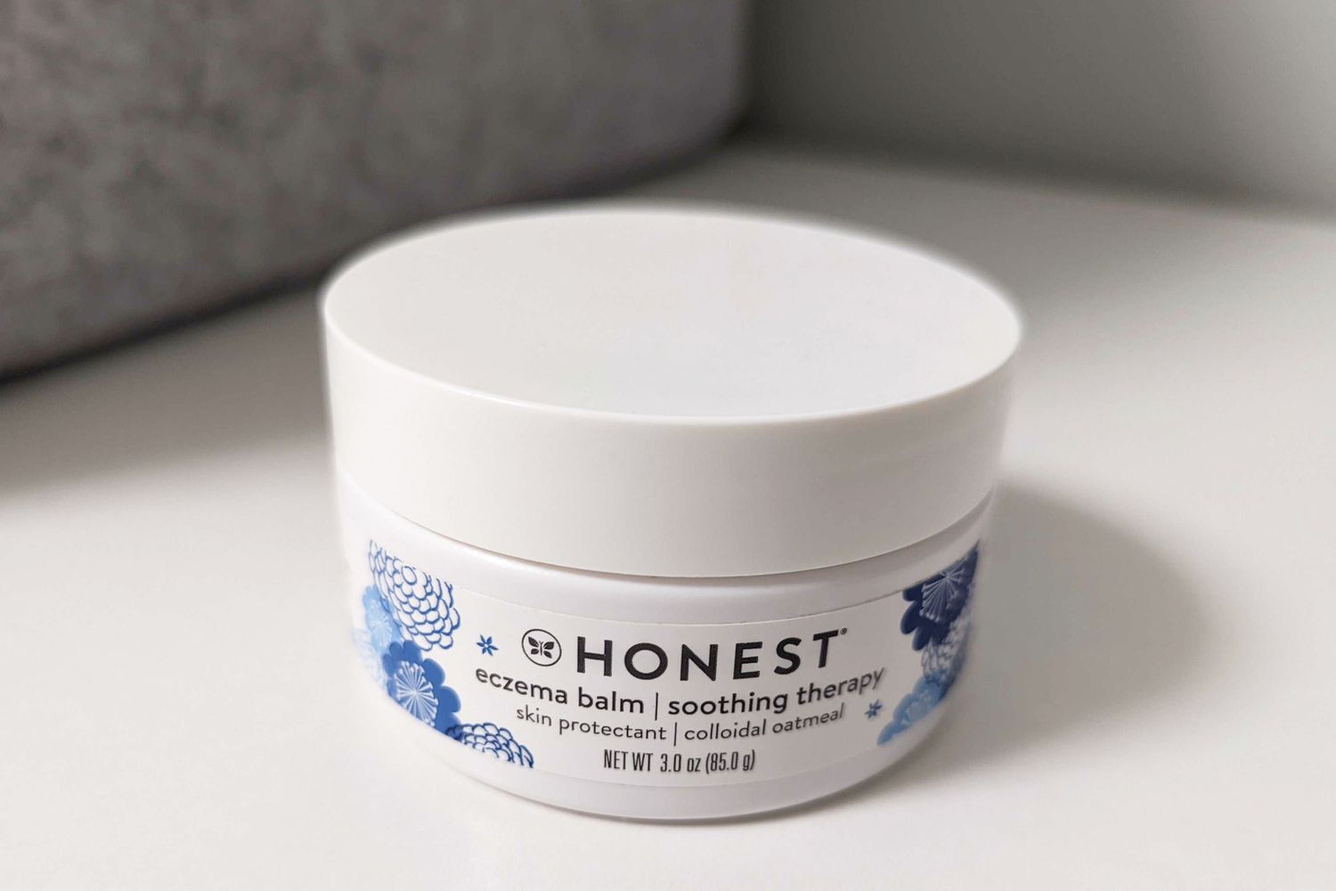 Tub of Honest Eczema Balm displayed on a white counter