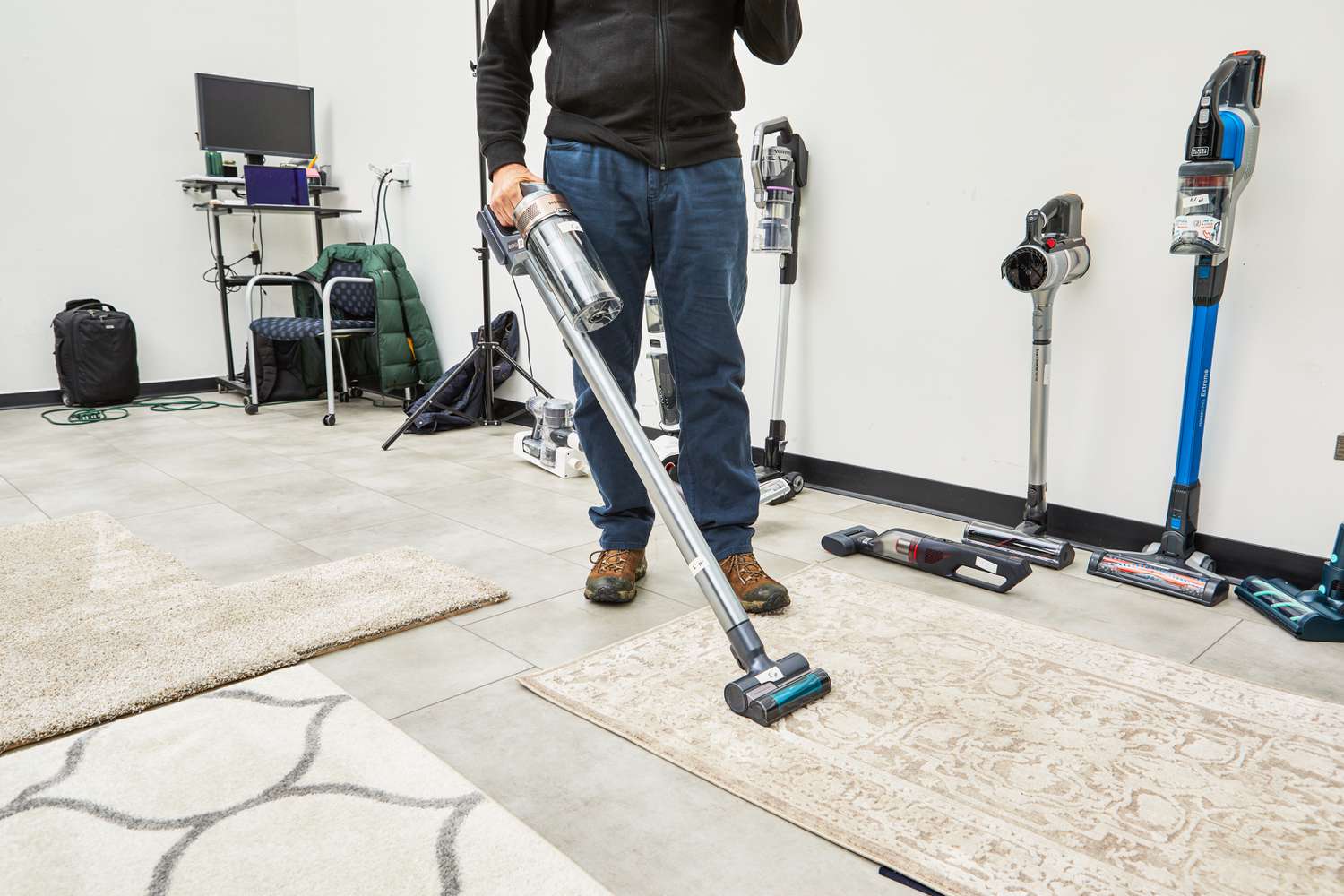 Person cleaning a rug with a Samsung Jet 75 Cordless Stick Vacuum