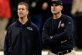 John Harbaugh and Jim Harbaugh speak during warm ups prior to Super Bowl XLVII on February 3, 2013 in New Orleans, Louisiana.