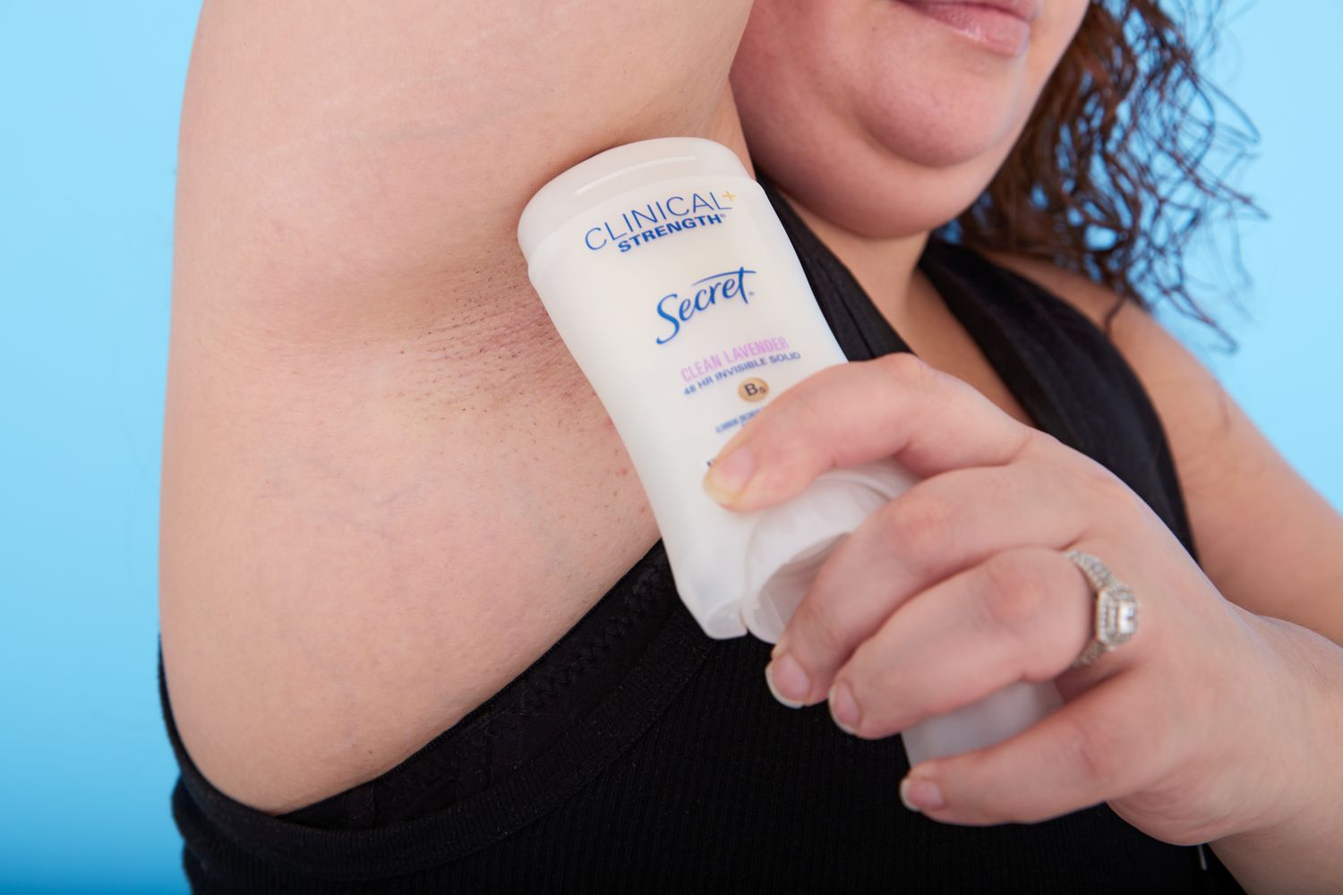 A person applying Secret Clinical Strength Invisible Solid Antiperspirant and Deodorant