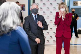 Dr. Anthony Fauci (C) waves as US First Lady Jill Biden (R) introduces him as an American Hero as they tour the vaccination center at the Children's National Hospital in Washington, DC on May 20, 2021.