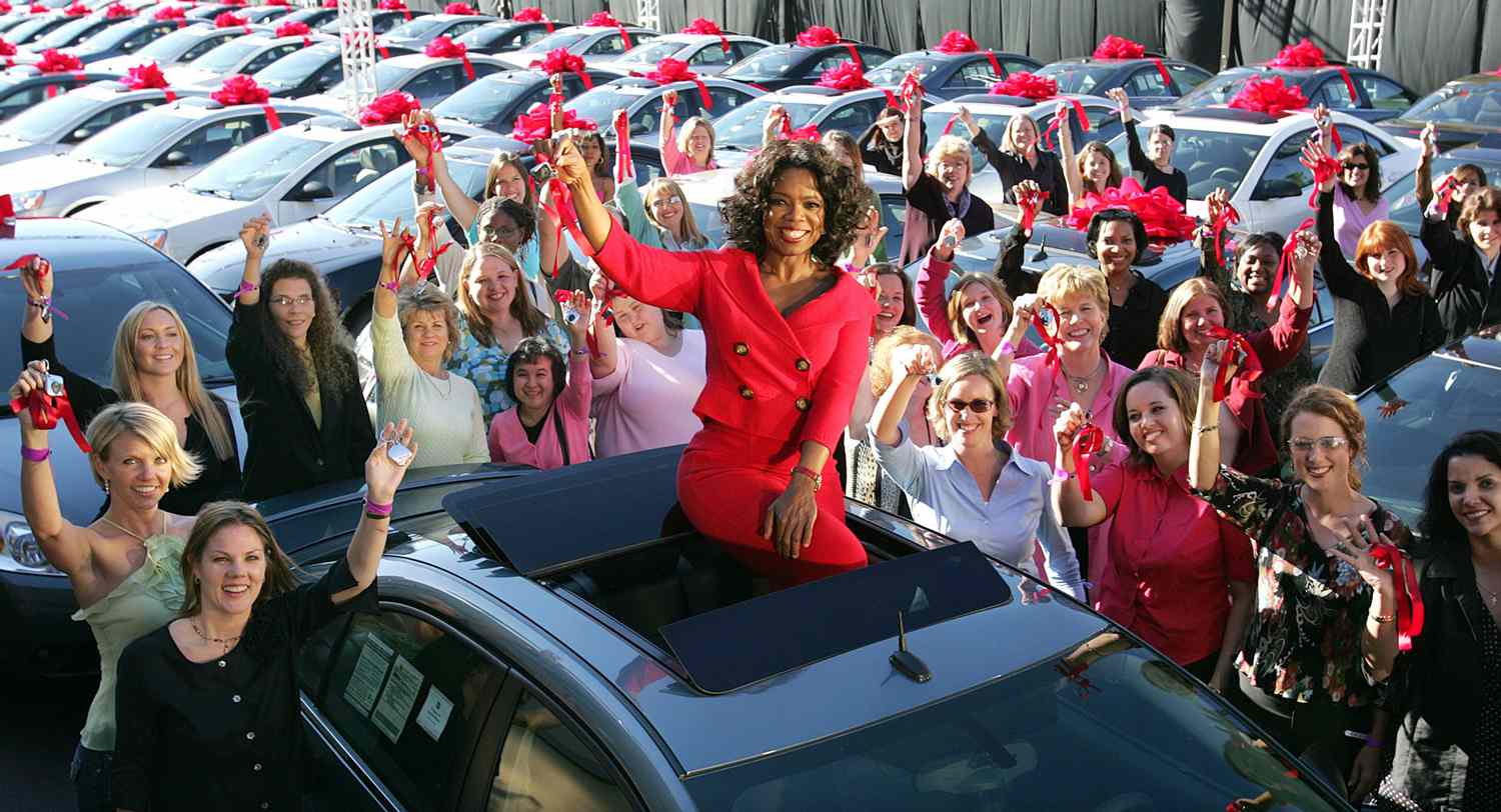 RGB 1929B308 RGB 18781A0B Talk show host Oprah Winfrey sits atop a Pontiac G6 outside her Chicago studios Thursday, Sept. 9, 2004, surrounded by some of the 276 people from her audience who each received one of the new cars at the start of the show to celebrate the premier of her 19th season. Winfrey said the audience members were particularly chosen because their friends or loved ones had told the show about their need for a new car.
