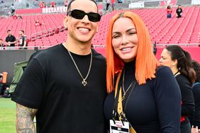 Daddy Yankee and his wife Mireddys González pose for a photo on the field before the game between the Tampa Bay Buccaneers and the Carolina Panthers at Raymond James Stadium on January 01, 2023 in Tampa, Florida