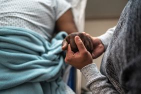 Son holding father's hand at the hospital, Man in hospital bed