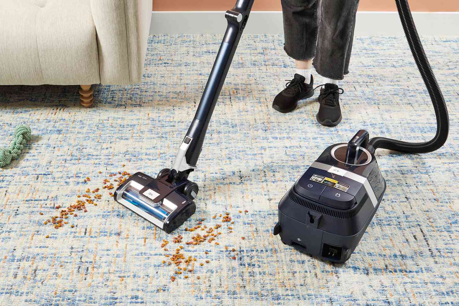 Person cleaning dog food from a rug using the Shark Canister Pet Bagless Corded Vacuum 