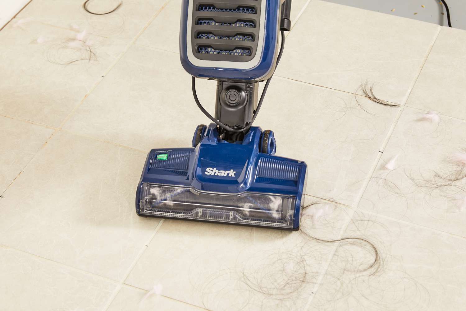 Shark NV151 Navigator Swivel Pro Complete Upright Vacuum used to clean the hair on the tile floor