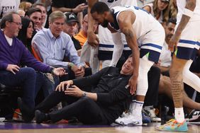 Head coach Chris Finch of the Minnesota Timberwolves grabs in leg in pain after a collision with Mike Conley #10 during the second half of game four of the Western Conference First Round Playoffs against the Phoenix Suns at Footprint Center on April 28, 2024 in Phoenix, Arizona.