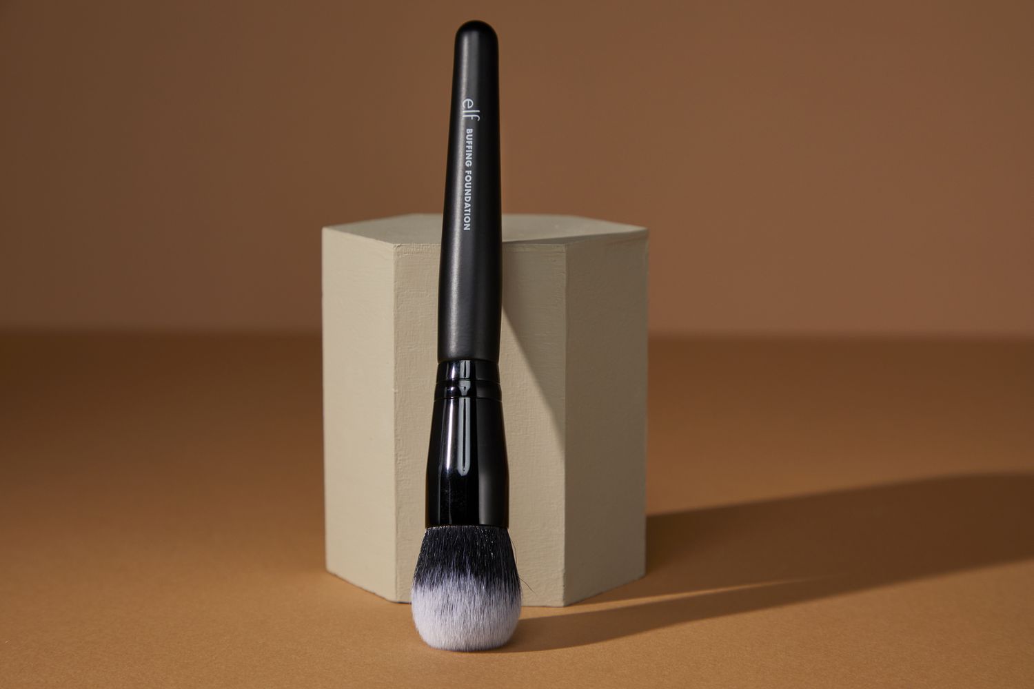 e.l.f. Cosmetics Buffing Foundation Brush leaning against a hexagon