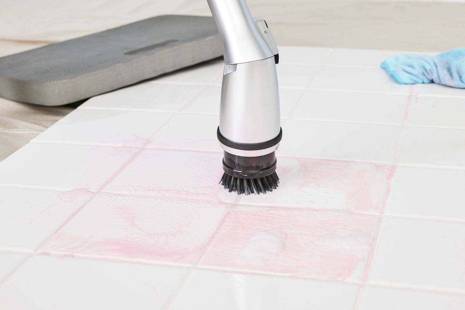 A HattyRoom Rechargeable Cordless Electric Spin Scrubber cleans white tile