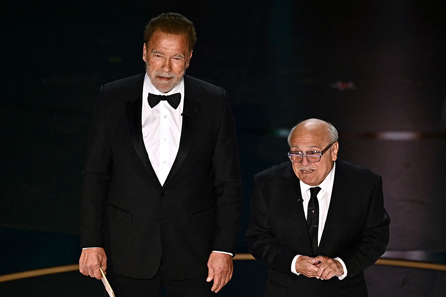 US actor Danny DeVito (R) and Austrian-US actor and former Governor of California Arnold Schwarzenegger present the award for Best Visual Effects onstage during the 96th Annual Academy Awards at the Dolby Theatre in Hollywood, California on March 10, 2024. 