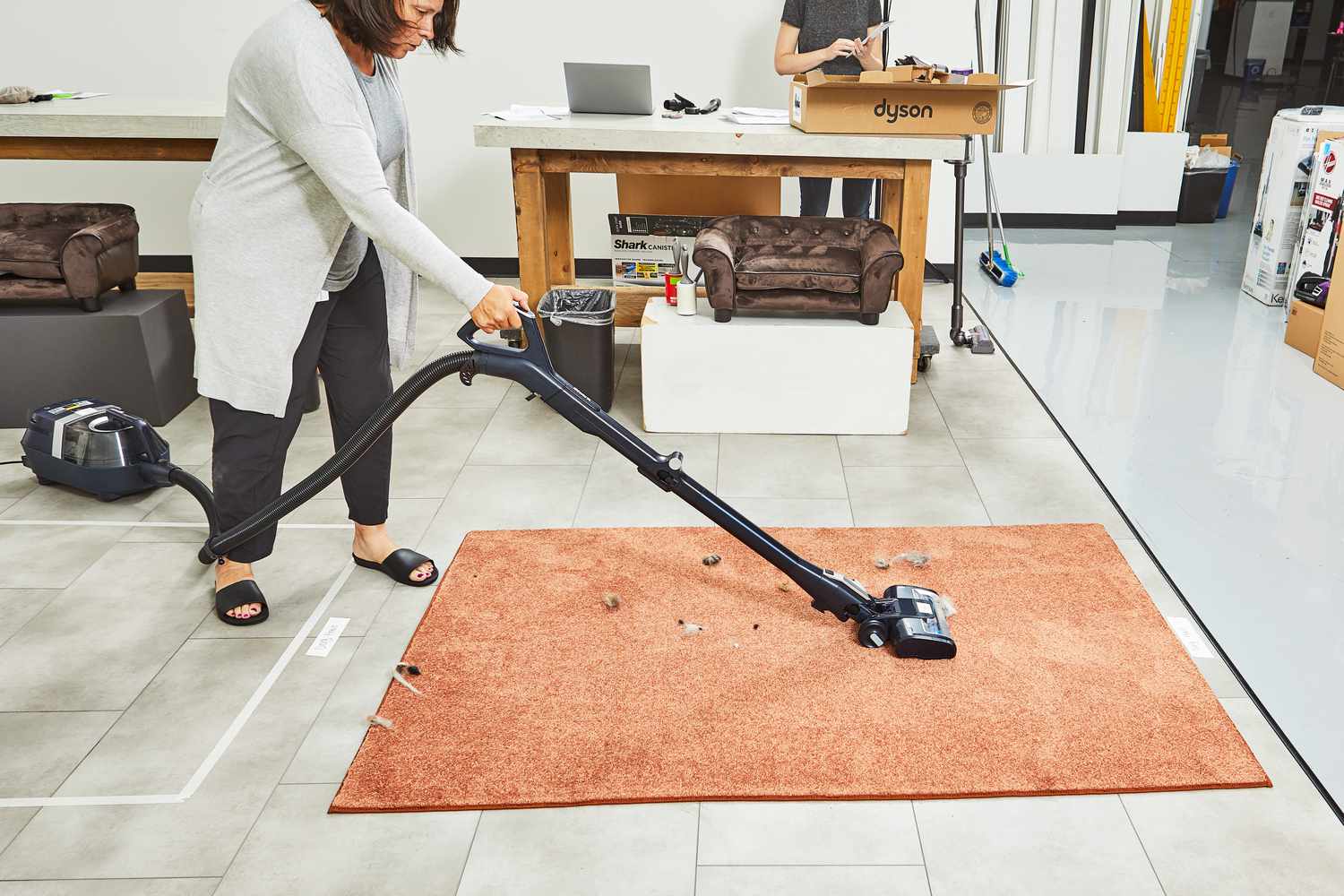 Person using the Shark Canister Pet Bagless Corded Vacuum to clean dust on carpet