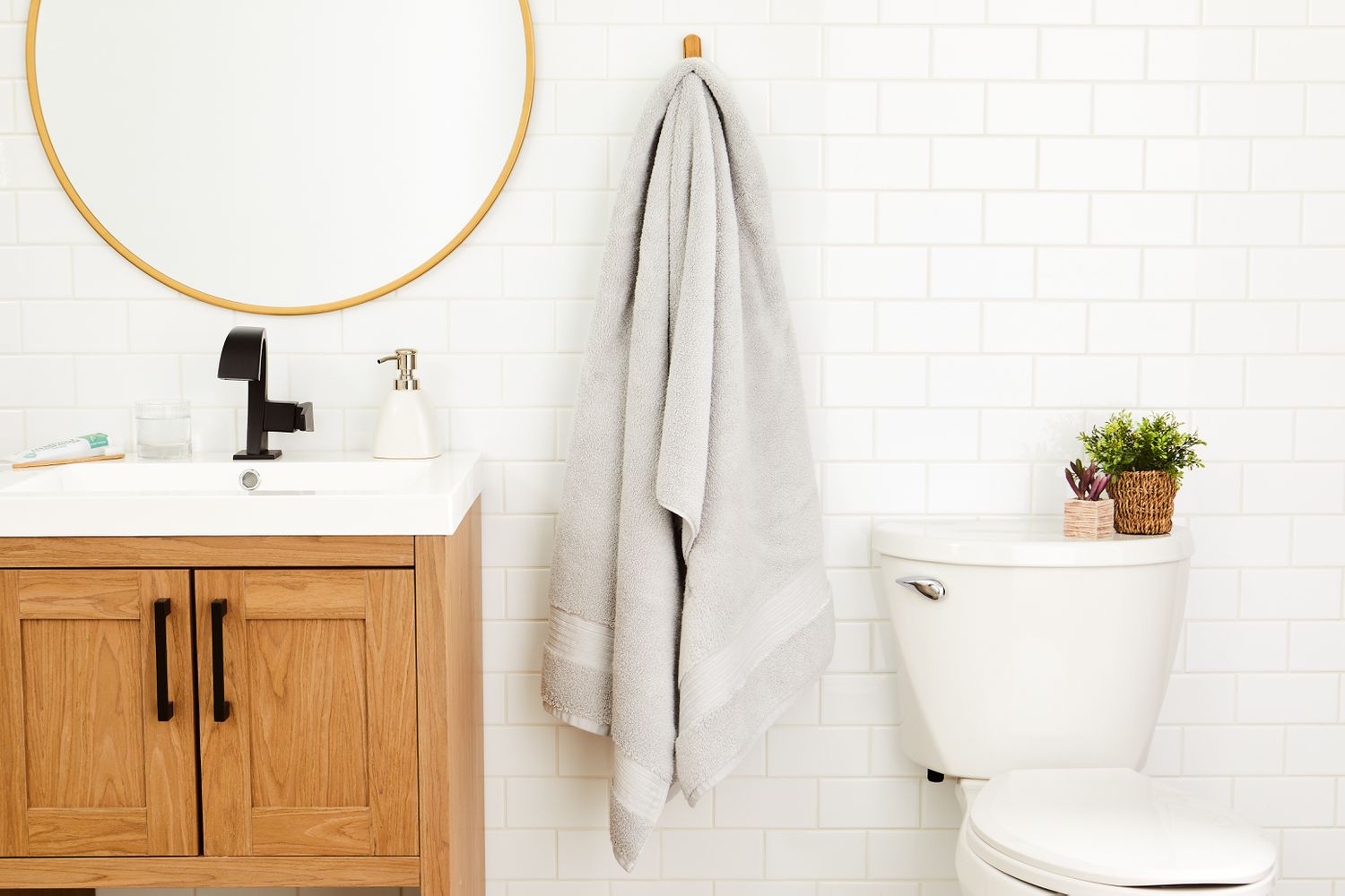 Boll & Branch Plush Bath Towel hung on hook in white bathroom 
