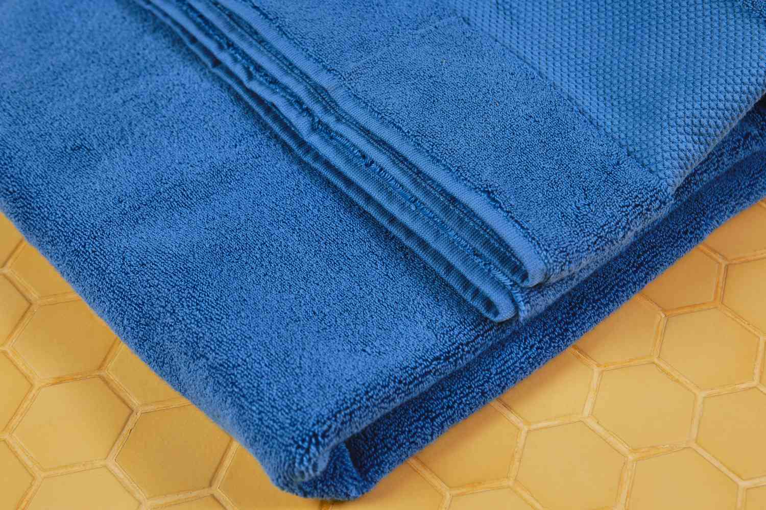 Closeup of Frontgate Resort Collection Bath Towel on yellow tile surface