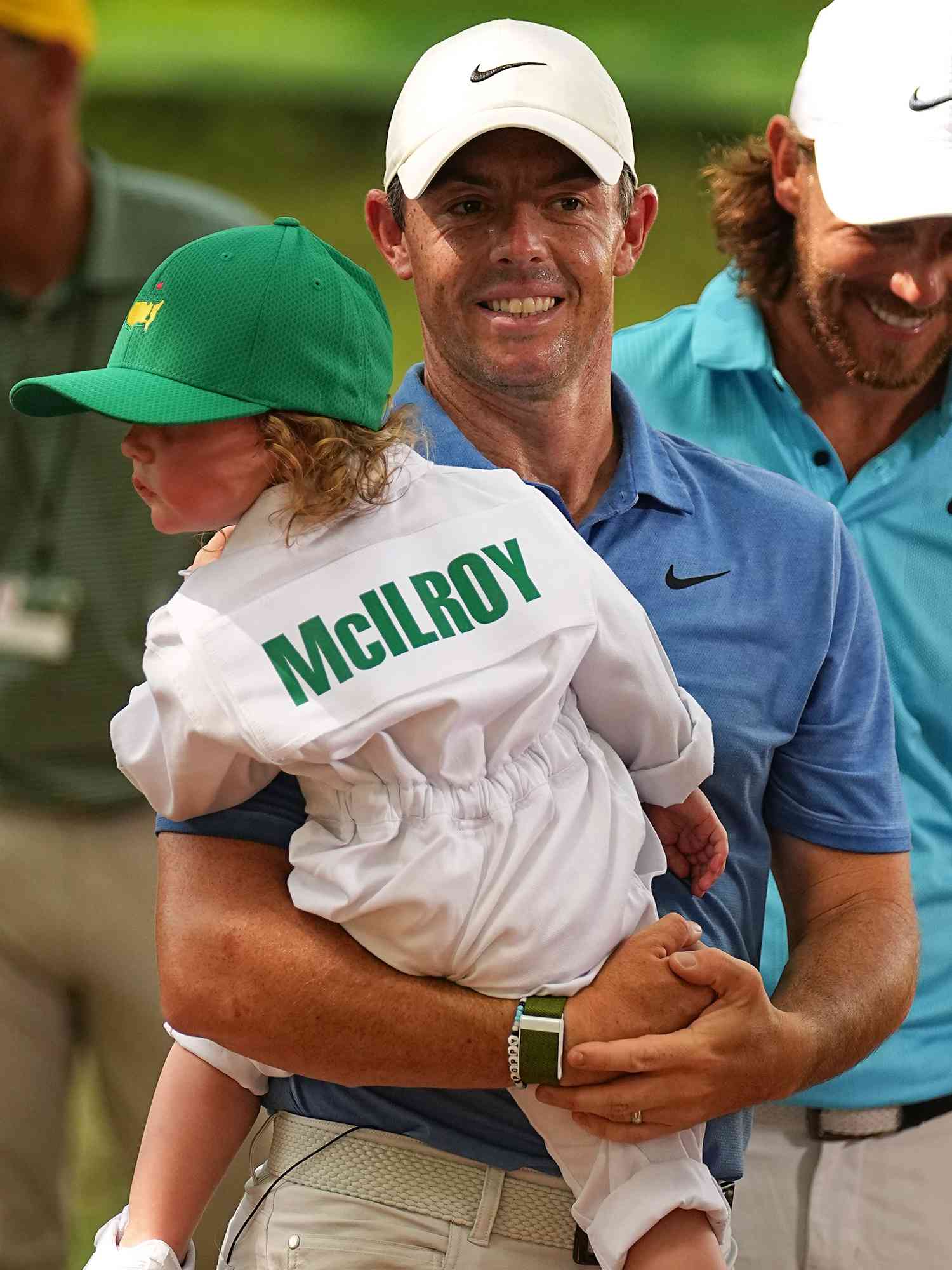 Rory McIlroy in action, walks and holds his daughter Poppy McIlroy during the Par 3 Contest prior to the Masters Tournament at Augusta National. 