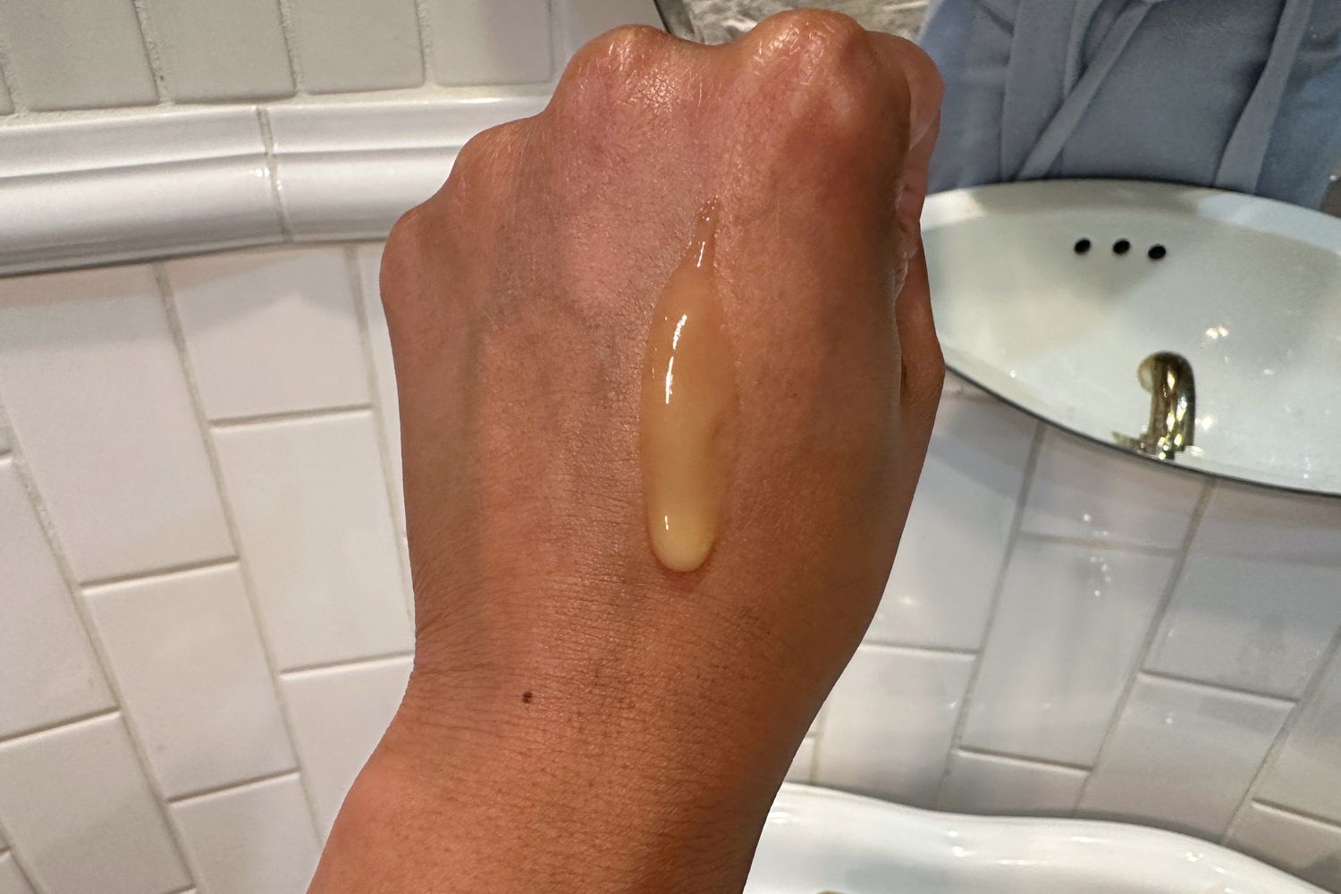 Back of a hand with L'Oreal Paris Cell Renewal Anti-Aging Midnight Serum dripping down