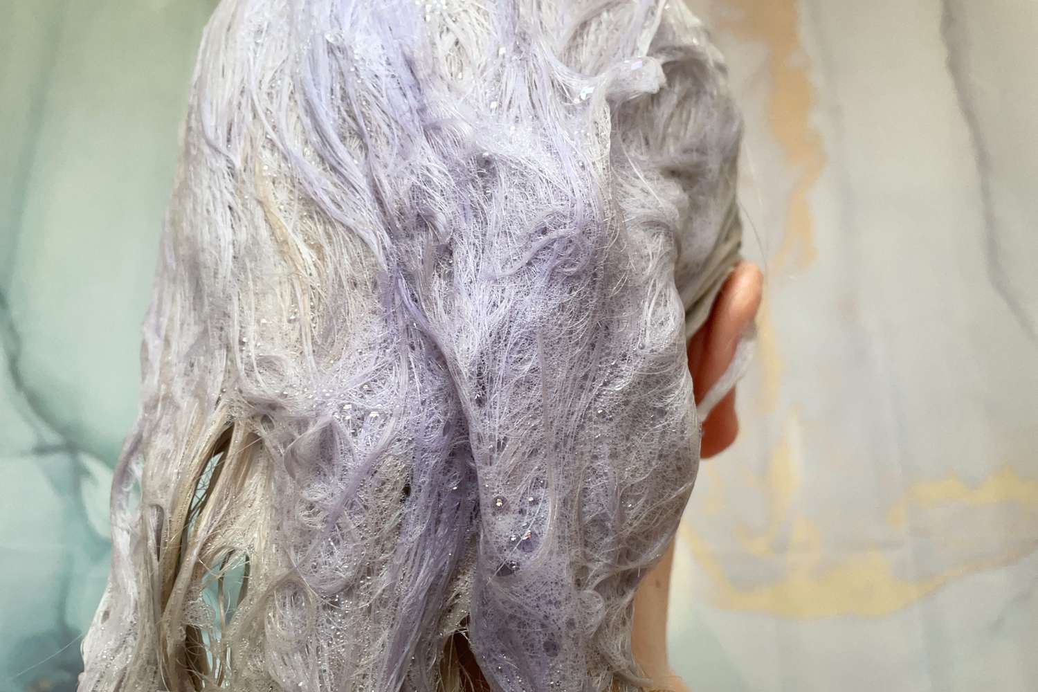 A person applies Clairol Professional Shimmer Lights Purple Shampoo