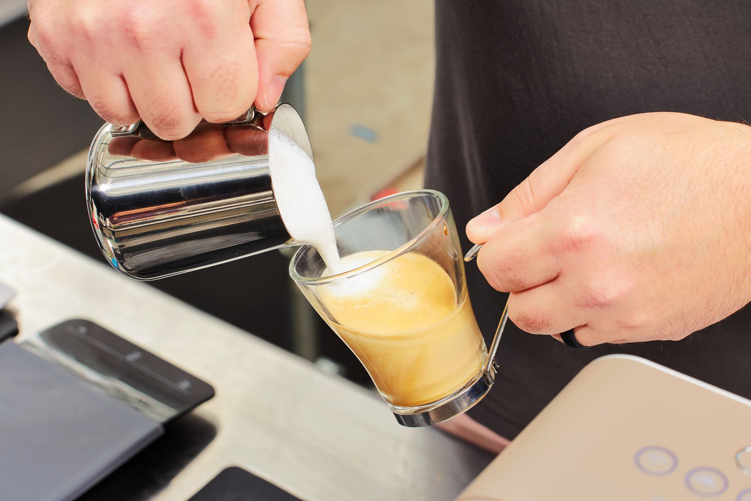 Frothed milk being poured into espresso brewed using the SMEG Medium Fully-Automatic Coffee Machine.