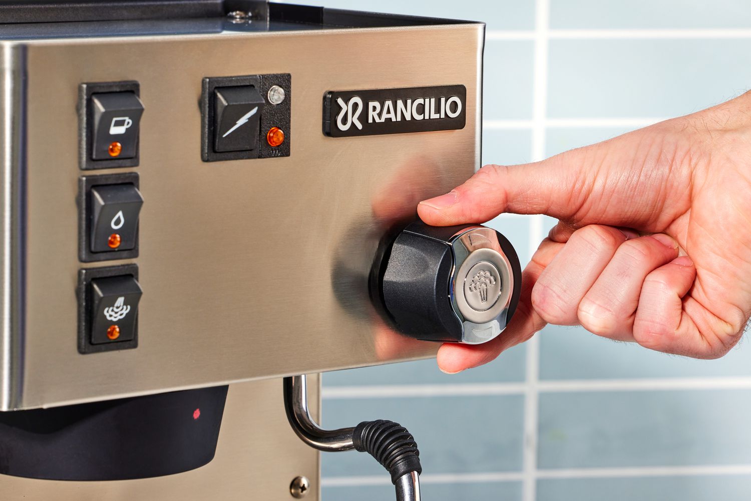 A hand turning the steamer control of the Rancilio Silvia Espresso Machine.