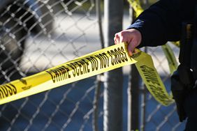 A San Mateo County Sheriff's Department officer puts up police tape at a crime scene after a shooting in Half Moon Bay, Calif., on Jan. 24, 2023