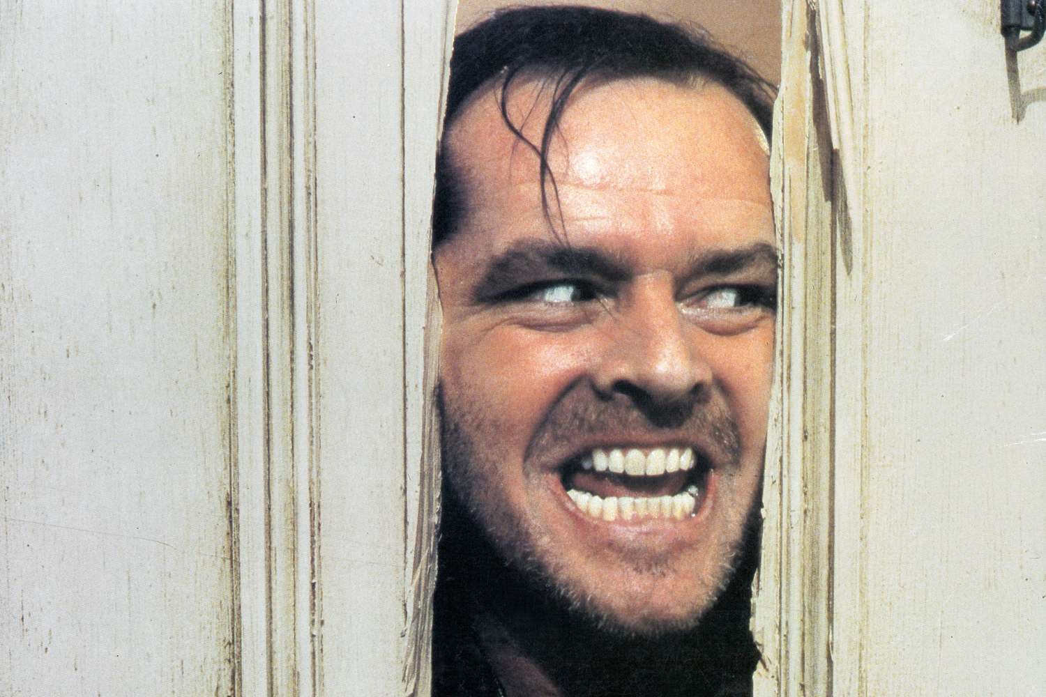 Jack Nicholson peering through axed in door in lobby card for the film 'The Shining', 1980. 