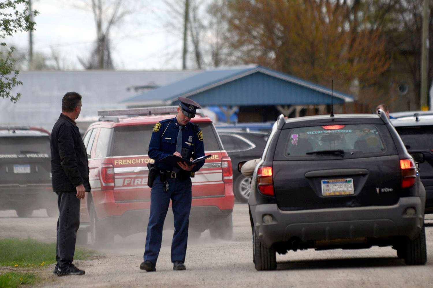 A law enforcement official monitors the perimeter of the Swan Creek Boat Club after a driver crashed a vehicle through a building where a children's birthday party was taking place, Saturday, April 20, 2024, in Berlin Township, Mich.