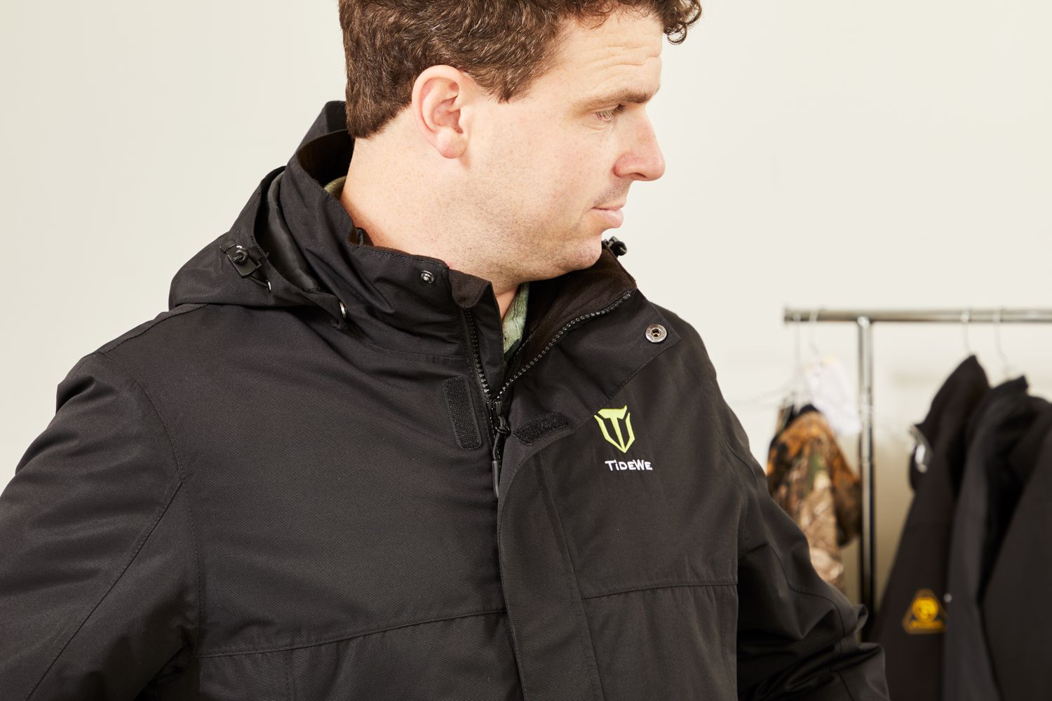 Person wearing the TideWe Mens 3-in-1 Heated Jacket with Battery Pack with other jackets in background