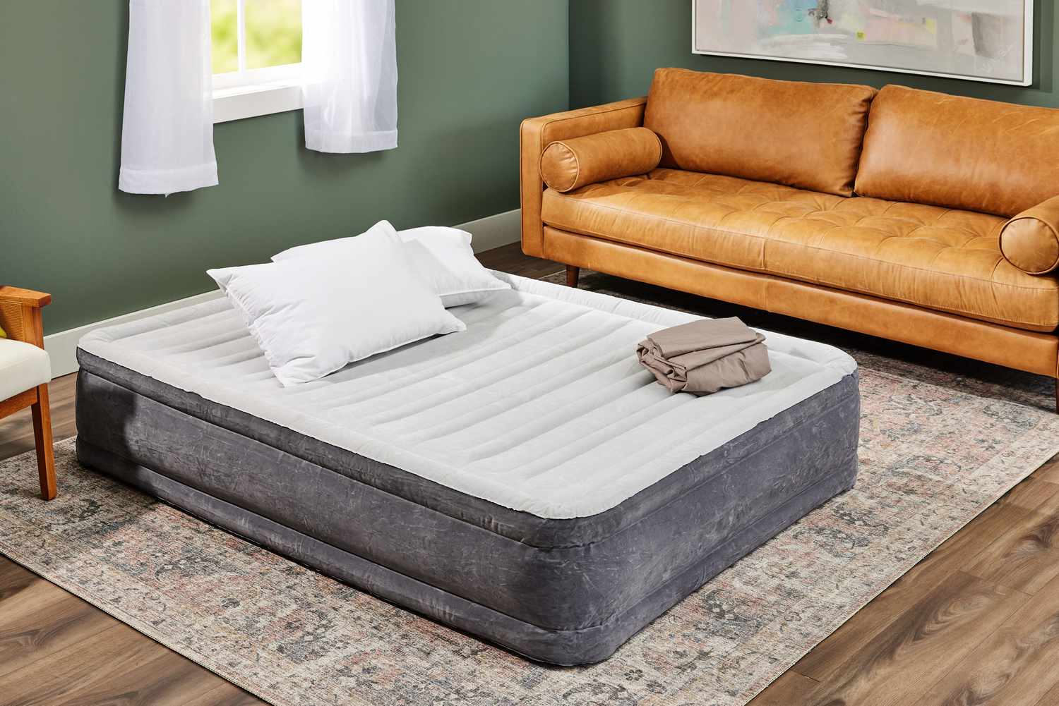 Intex Dura-Beam Comfort Mid-Rise Air Mattress inflated near a window and a couch