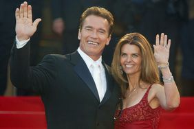 Arnold Schwarzenegger with his wife Maria Shriver wave to fans as the couple arrives for the screening of the film "Les Egares" at the Palais des Festivals during the 56th International Cannes Film Festival on May 16, 2003 in Cannes, France