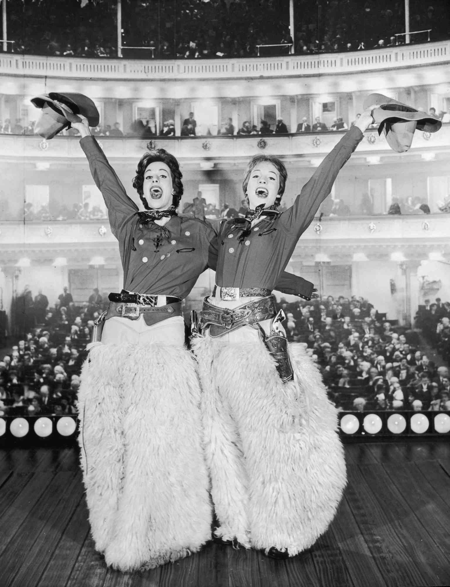 American actor and comedian Carol Burnett (left) and British singer and actor Julie Andrews perform on-stage in Old Western outfits