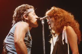 1984-Photo shows Bruce Springsteen singing on stage in concert along with back-up singer Patti Scialfa