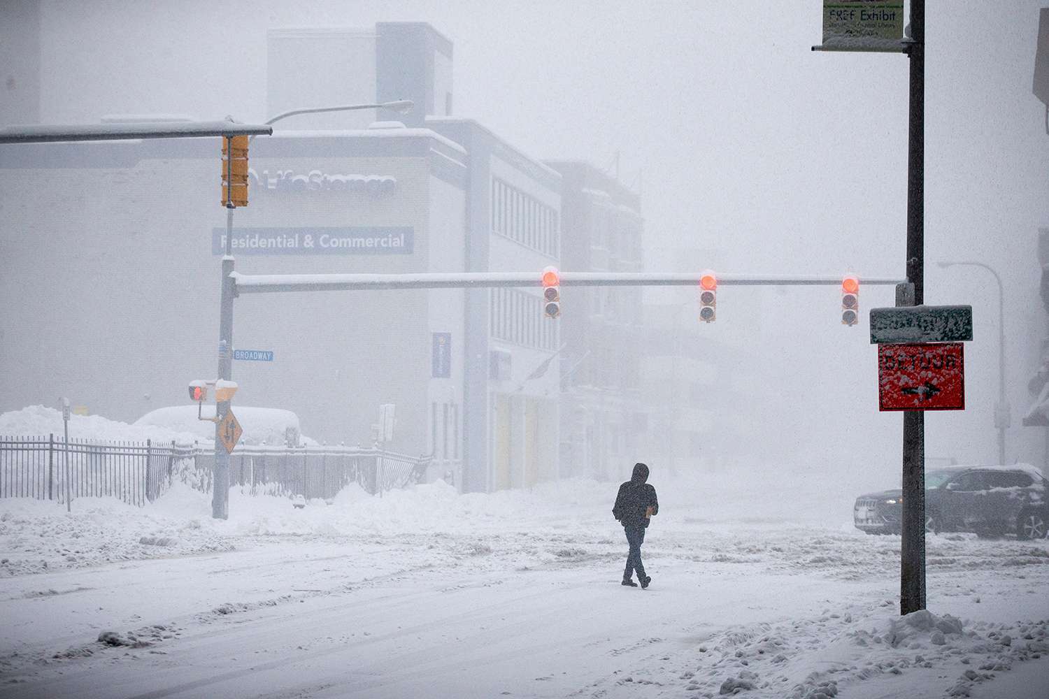 Person crosses Ellicott Street as snow falls, in Buffalo, N.Y. A dangerous lake-effect snowstorm paralyzed parts of western and northern New York, with nearly 2 feet of snow already on the ground in some places and possibly much more on the way