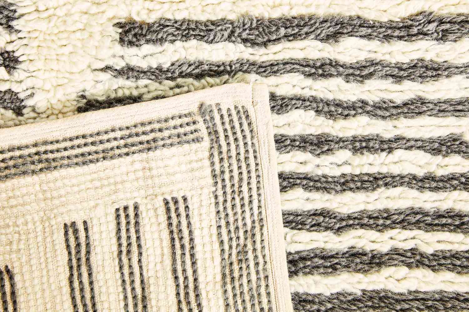 Close up of the AllModern Machine Washable Hand-Woven Wool Ivory/Charcoal Area Rug