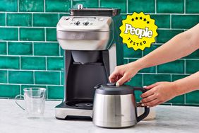 A pair of hands holding the coffee pot of the Breville The Grind Control